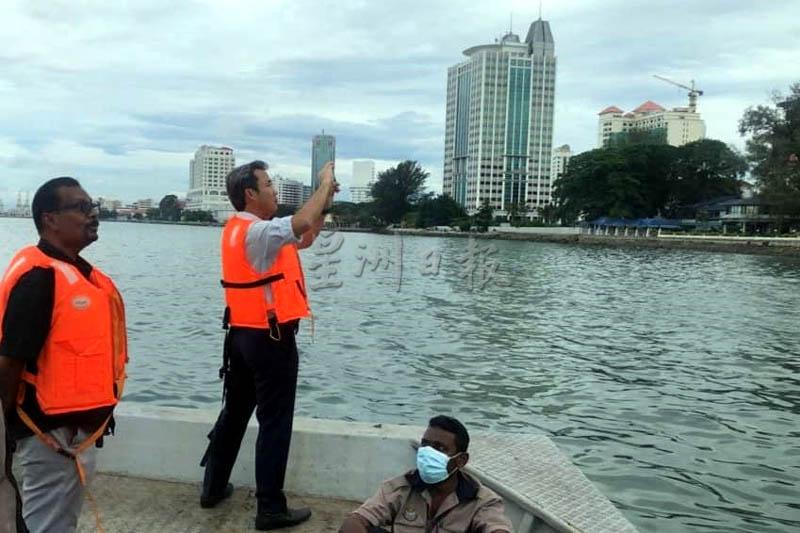 槟岛市长拿督尤端祥（左二）及市政厅官员前往海面检查污染情况。