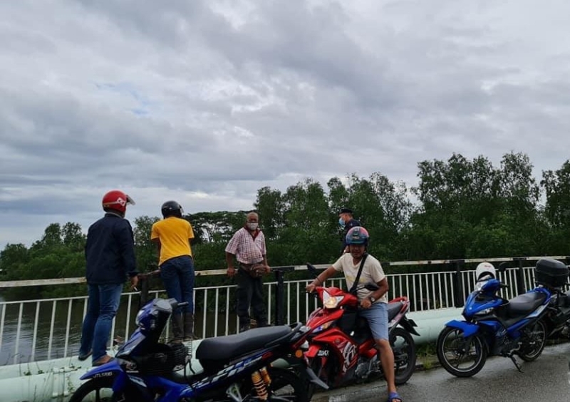华裔男子从峇株桥纵身跳入河中后失踪，引来许多民众围观。（互联网照片）