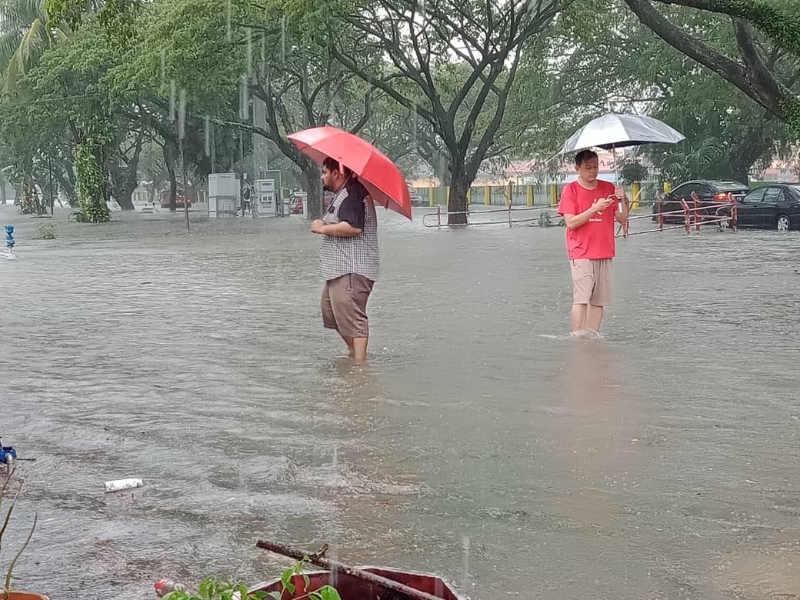 良木园居民冒雨撑伞了解受灾程度，对周围一片汪洋的画面，只能大感无奈和无助。