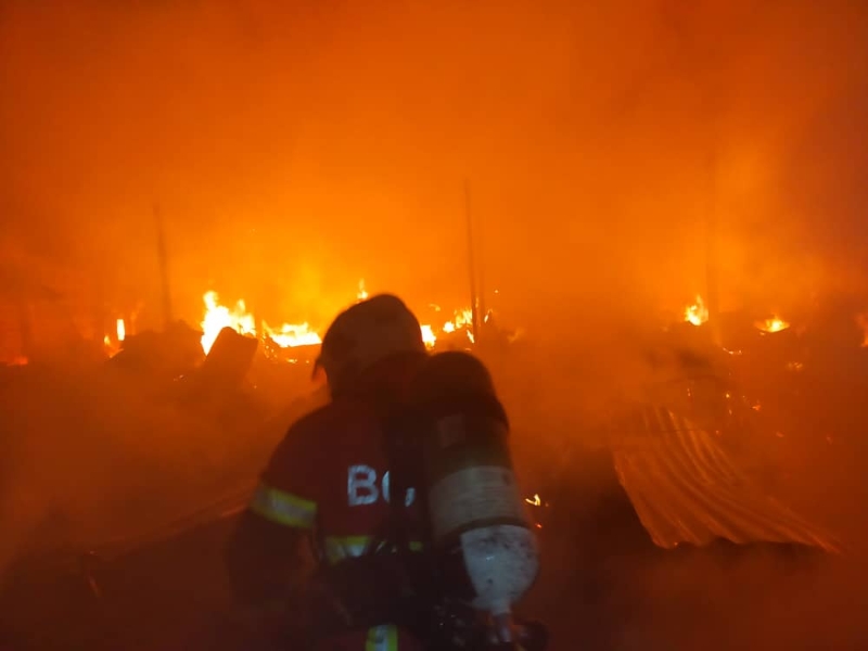 消拯人员佩戴氧气筒准备进入火场，以确认是否有人受困在火场里。