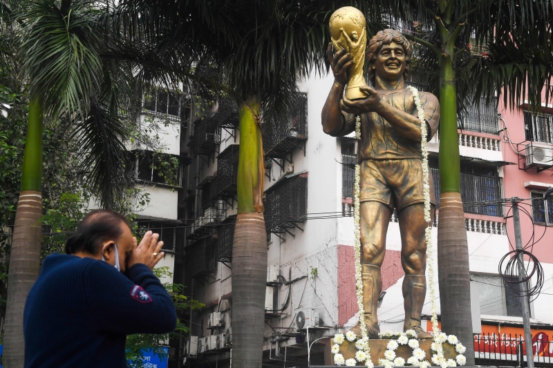 在印度加尔各答，一名球迷在马拉纳多肖像前向他致意。