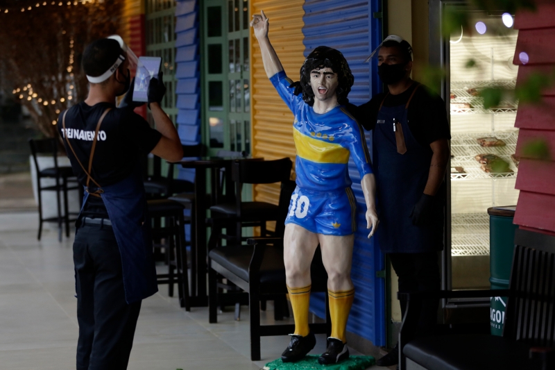 在巴西的巴西利亚一间主题酒吧，马拉多纳的肖像吸引球迷前来拍照。