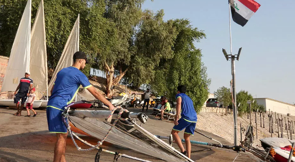 Iraqi Water Sports Federation members carry a sail on the banks of the River Tigris. AFP