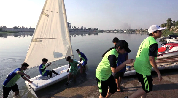 Members of the Iraqi Water Sports Federation carry a sail boat on the banks of the river Tigris. AFP