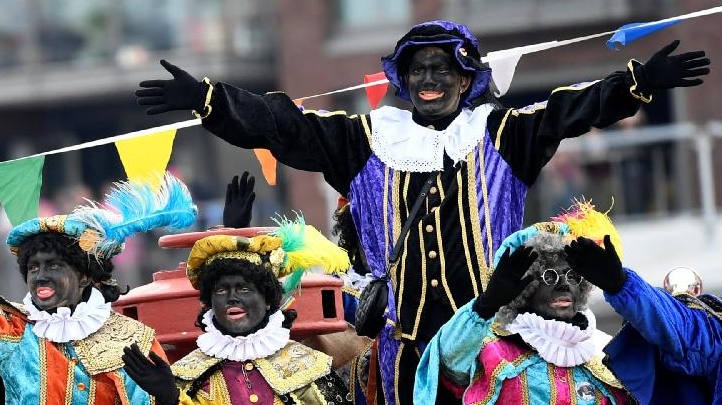 Zwarte Piet arrives by boat at the harbor of Scheveningen.