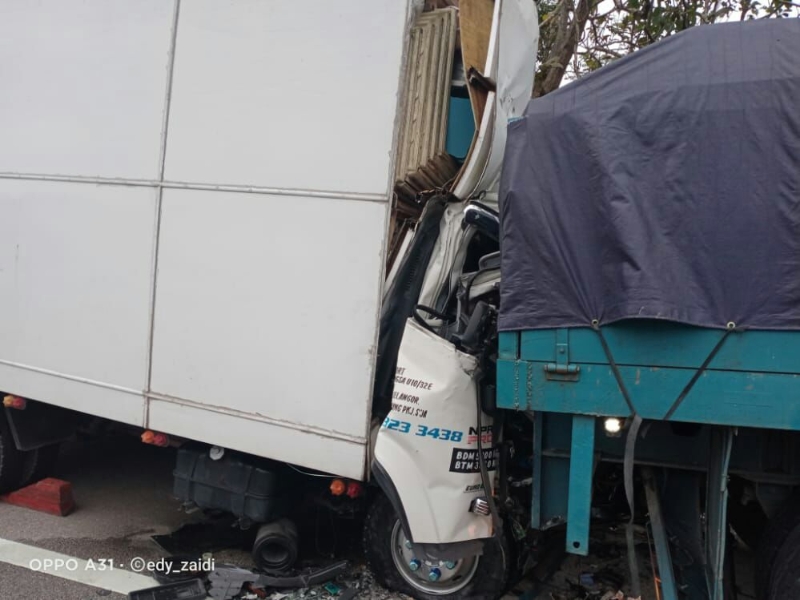 2小型货柜罗里猛撞停放在大道旁的拖格罗里后部，车头几近压扁。