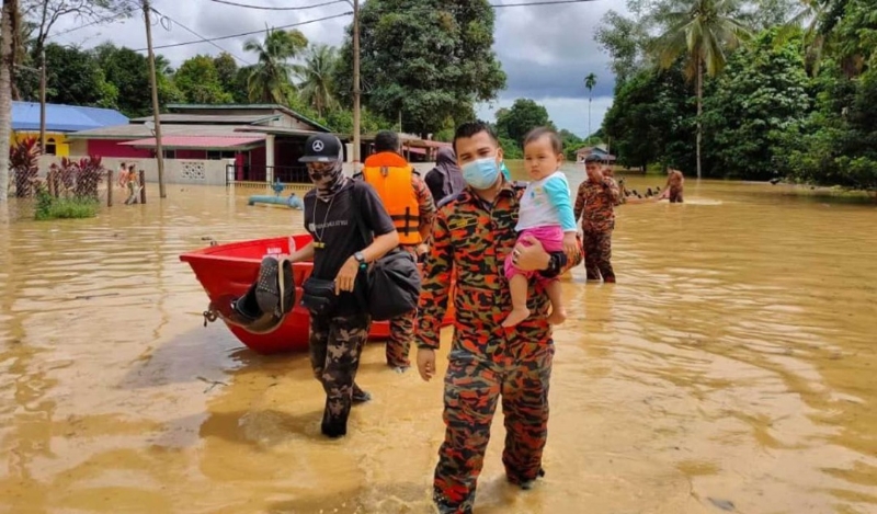 救援人员协助疏散甘马挽亚逸布爹多个甘榜的村民到疏散中心。