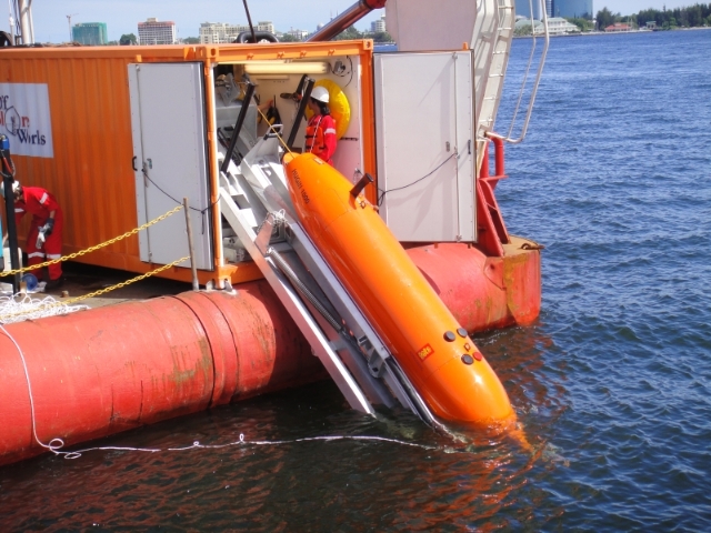 探测船的工作人员准备探测仪器放入海里，郑伊菱将根据仪器的资料分析集成报告。