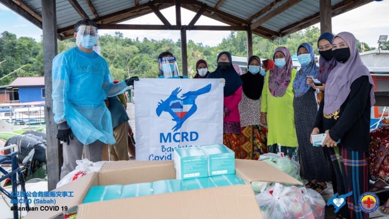 救援赈灾与发展事工和沙巴救援赈灾事工协力把口罩和医疗物资派送到当地人的手中。