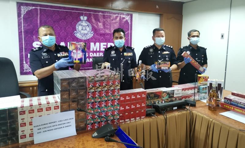 马祖基（左一起）、副警区主任罗斯兰及刑事调查主任陈木华（右二）展示起获的私烟、烈酒及爆竹。