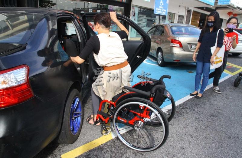 王秀莲示范，只有在宽敞空间的停车格，才能自行順利把轮椅放入车内。