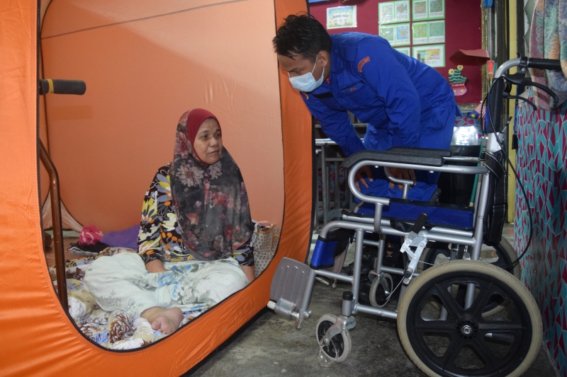莫哈末纳兹米（右）慰问瘫痪、被安置在临时疏散中心的再娜柏德拉曼。（马新社照片）