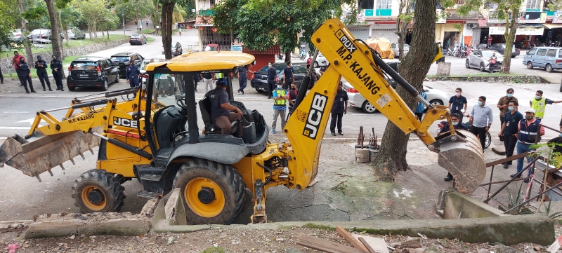 市议会出动铲泥机将早市违建物拆除。