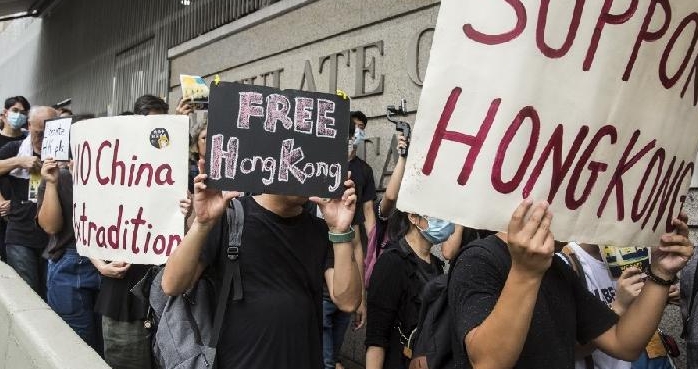 File photo showing Hong Kong protesters hold signs while marching past the US Consulate to deliver a petition. AFP File photo showing Hong Kong protesters hold signs while marching past the US Consulate to deliver a petition. AFP