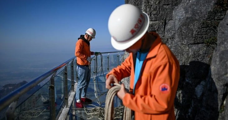 The litter-pickers abseil down the cliff face, their colleagues anchoring them at the top. They are hauled back up via a system of pullies when they finish. AFP