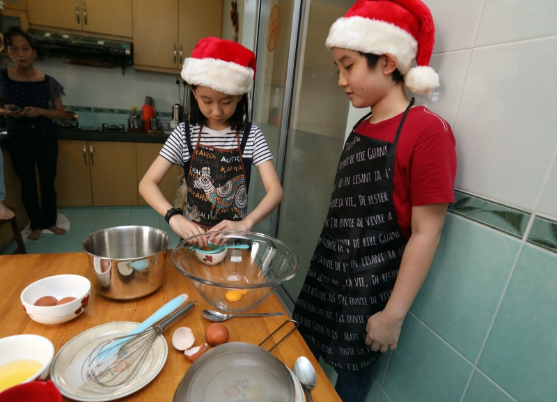 郭懿乐（右）与郭懿萱兄妹俩齐心合力，制作松软可口的巧克力戚风蛋糕到网上义卖，以帮助患病儿童筹款，实现他们的愿望。