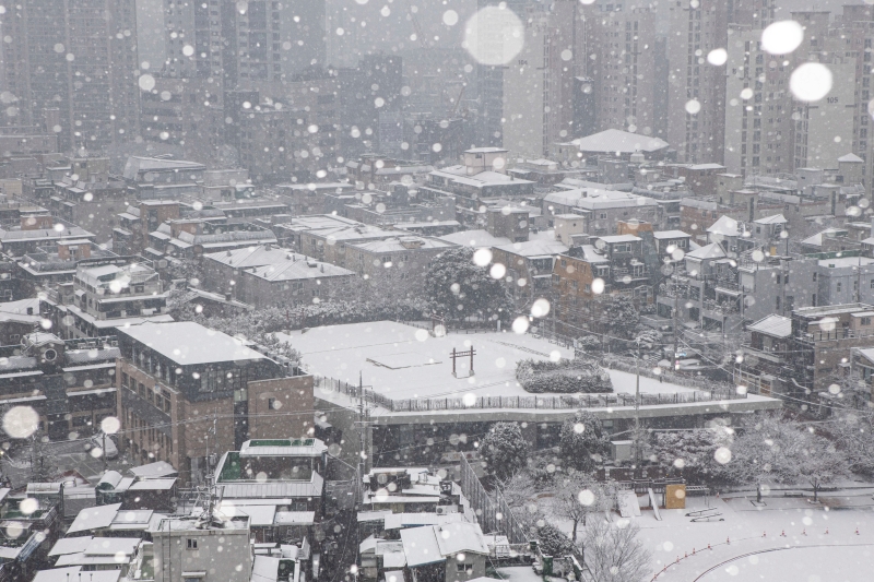 韩国部分地区迎来大雪，首都首尔的建筑物顶部皆被白雪覆盖，一片银白。（欧新社照片）