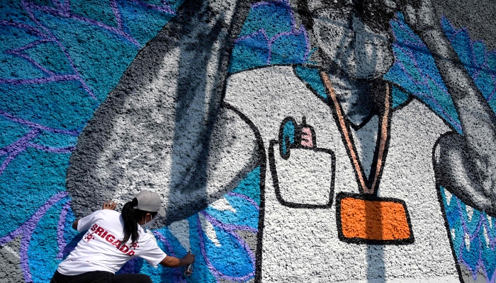 Students and professors from the Faculty of Arts and Design of National Autonomous University of Mexico (UNAM) painting a mural to honor health workers fighting the coronavirus on the walls of the National School of Nursing and Obstetrics in Mexico City. AFP