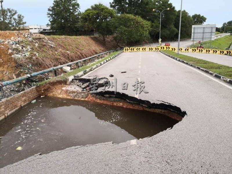 长时间被水浸泡后的路面严重塌陷，形成一个大窟窿。