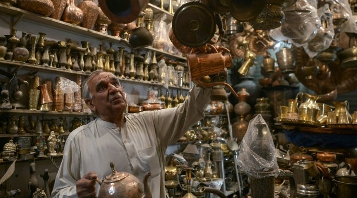 Khwaja Safar Ali, 75, arranges items in his antiques shop at the oldest Qissa Khawani or 