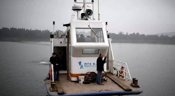 Yang Zeqiang's boat arrives at shore opposite Zhongba, a small island near the southwestern city of Chongqing. AFP