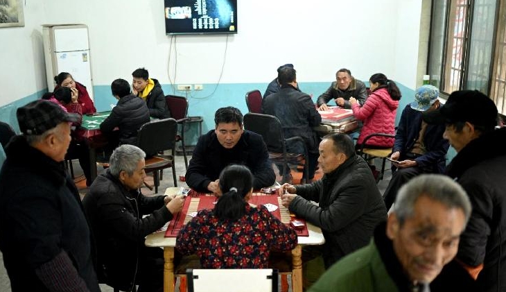 Yang Zeqiang's neighbors play cards at the ground floor of his house turned into a guesthouse in Zhongba. AFP
