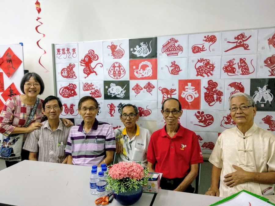 霹雳文艺研究会成员在今年“鼠不尽文艺情”新春聚会合照，背景为崔冰（左一）的剪纸作品。