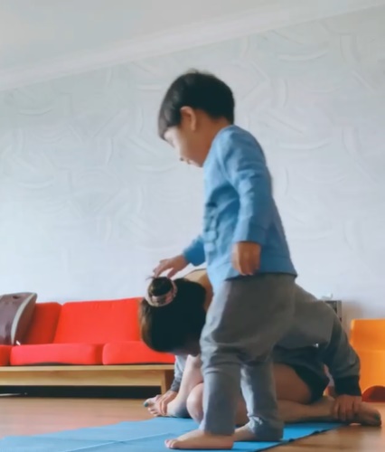 陈瑜做瑜伽时，原本乖乖看电视的小儿子突然走过来轻摸她的头，让她十分崩溃。