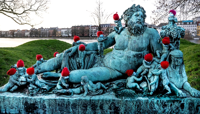 Small bronze statues at the statue Nilen (the Nile) in Copenhagen, Denmark, are covered with red caps and little masks. AFP
