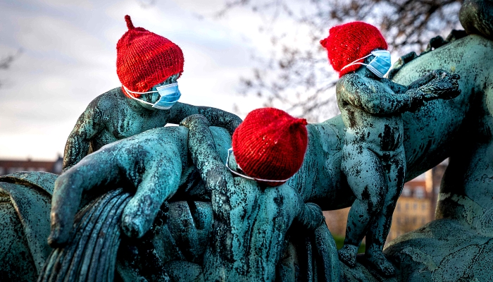 Small bronze statues at the statue Nilen (the Nile) in Copenhagen, Denmark, are covered with red caps and little masks. AFP