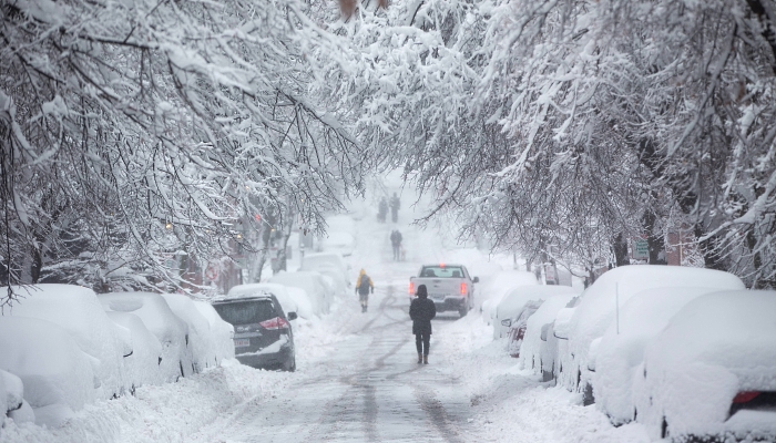 People walk down snow-covered Chestnut Street in Boston, Massachusetts. AFP