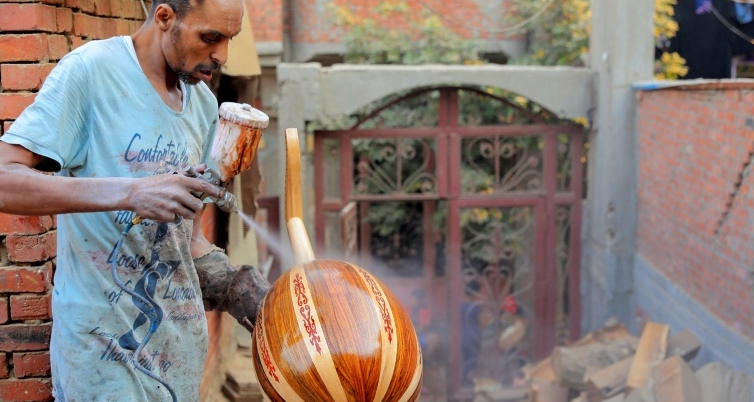 A worker sprays varnish onto an oud at a workshop in the Al-Marg district on the outskirts of Cairo. AFP
