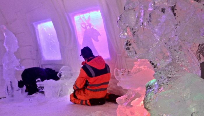 A worker puts the finishing touches to a room at the Arctic Snow Hotel built entirely out of snow and ice in Finland's snowy far north. AFP