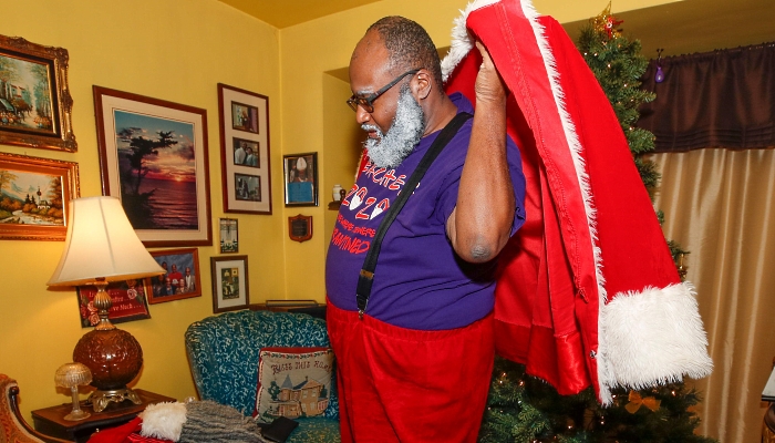 Andre Russel dresses as Santa Claus before his virtual appointment with a client at his home in Chicago. AFP