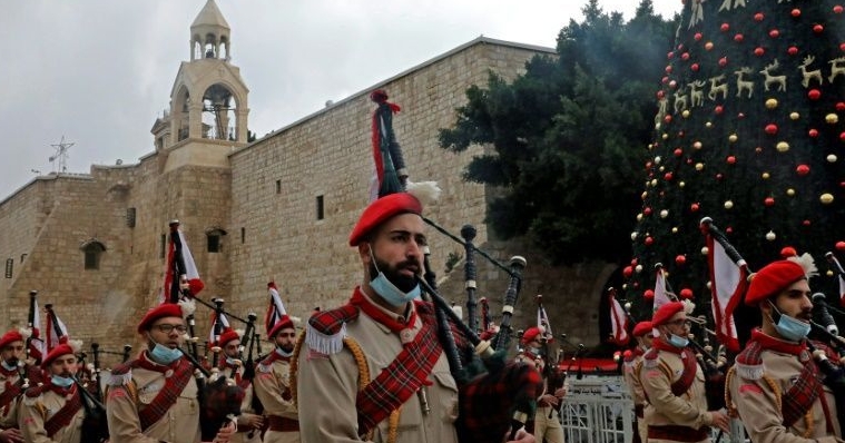 A Palestinian band parades in front of the Church of the Nativity in Bethlehem on Christmas Eve. AFP