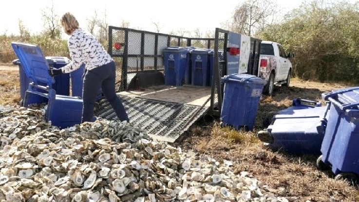Shannon Batte unloads bins full of oyster shells to be dumped back in the waters of Galveston Bay. AFP