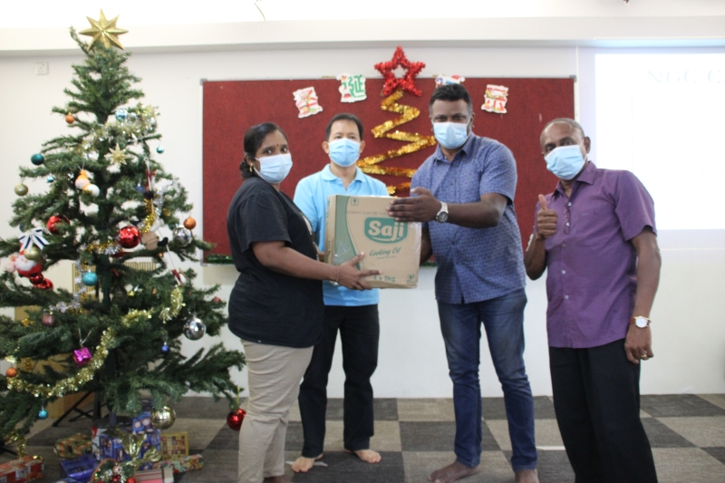 锺今旺传道（左二）与汝来州议员阿鲁古玛（右二）把“圣诞箱子”送给受惠者，并祝大家圣诞快乐。