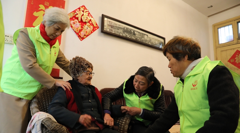 在南昌市东湖区刘将军庙社区有一家 “时间银行”。它里面存储的不是现实的金钱和财富，而是“时间养老金”。志愿者们的服务时长可以存入“时间银行”，等自己老了，有需要了，能够支取时间使用。图为“时间银行”的志愿者探访照料社区90余岁高龄的魏道珍老人。（图：新华社）