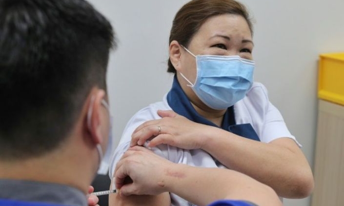 Coronavirus vaccine being given to senior staff nurse Sarah Lim as Singapore begins its vaccination exercise with the first batch of healthcare workers at the National Centre for Infectious Diseases (NCID). AFP