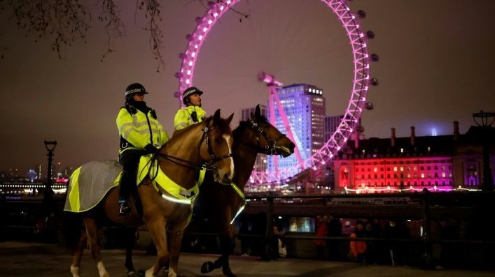 Mounted police officers patrol The Victoria Embankment opposite the London Eye in a near-deserted London late on New Year's Eve. AFP