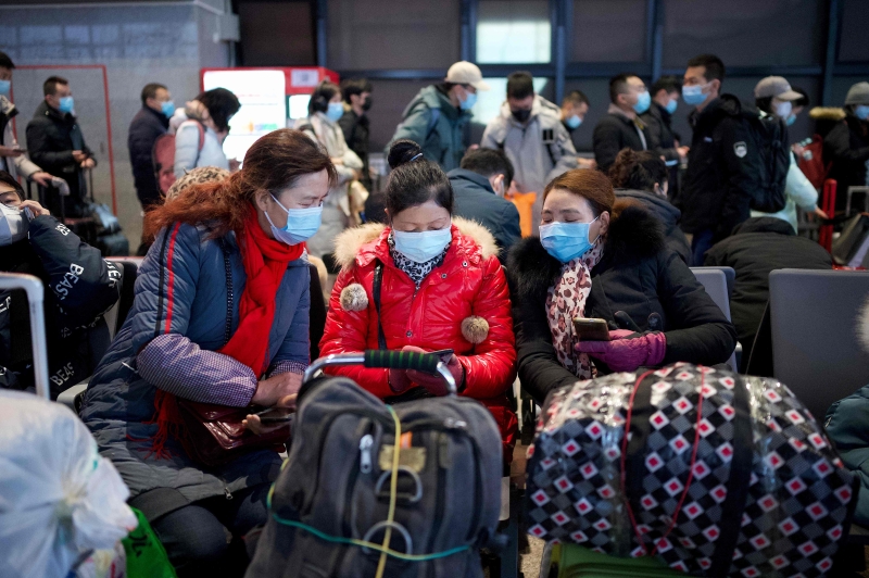 政府吁请公众“就地过年”，北京开始出现“提早回乡潮”。图为中国民众周四在北京西站候车准备返乡。(法新社照片)