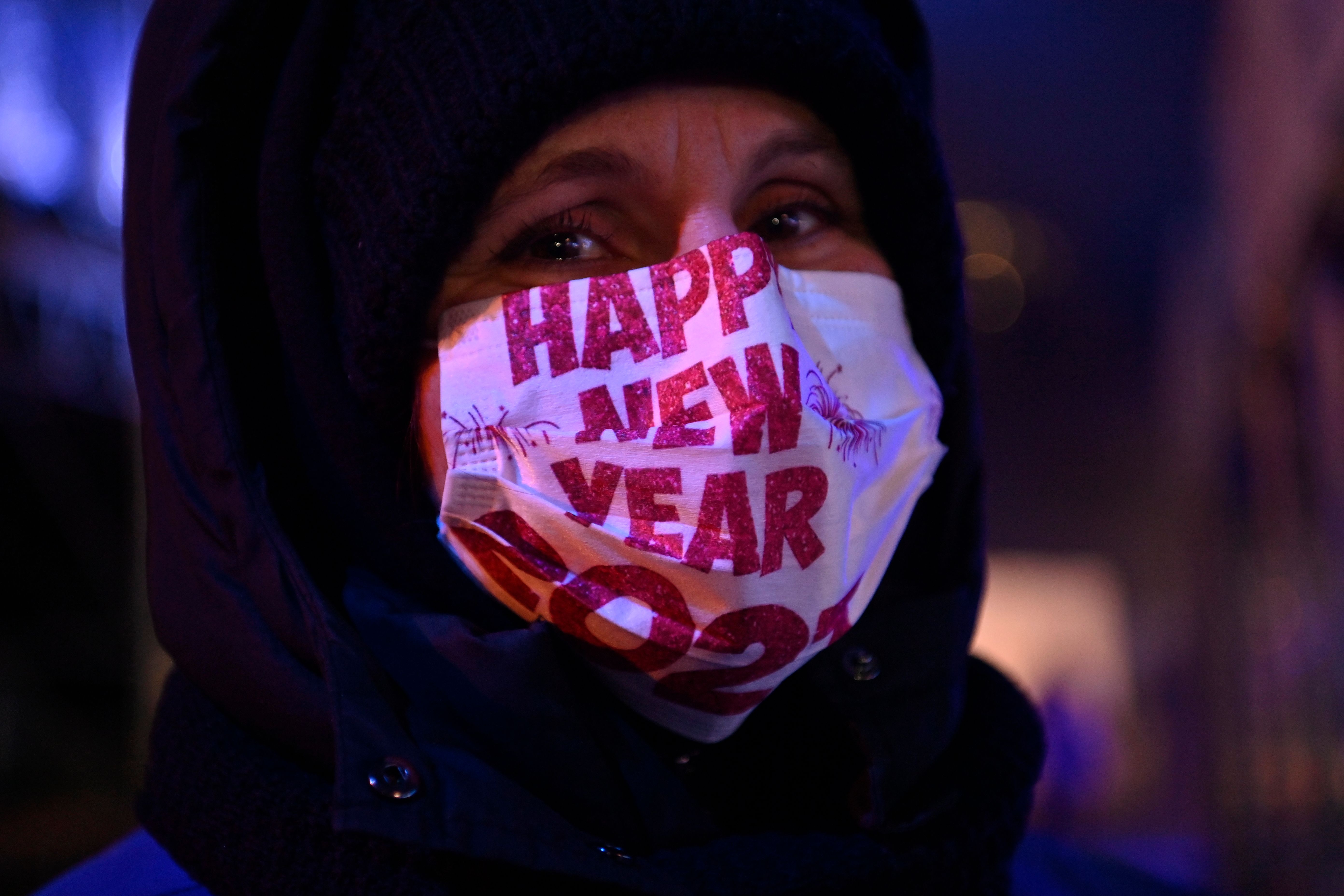 一名民众戴着口罩，上面印有2021年新年快乐的字样。