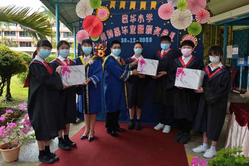 启华小学毕业生移交纪念品予朱玉慈（左三）及陈佩文（左四）。