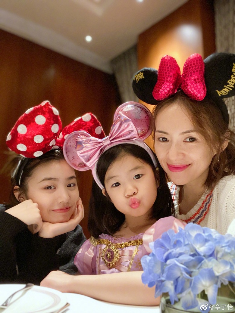 章子怡也分享与两个女儿戴着老鼠耳头饰的合照，对继女小苹果（左）付出的爱不比亲生女儿醒醒的少。