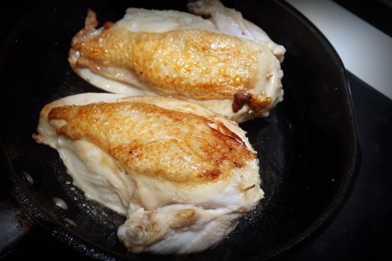 5.热锅后，将鸡胸肉放入锅里煎，带皮的那一面先煎，煎至金黄色后再翻另一面。