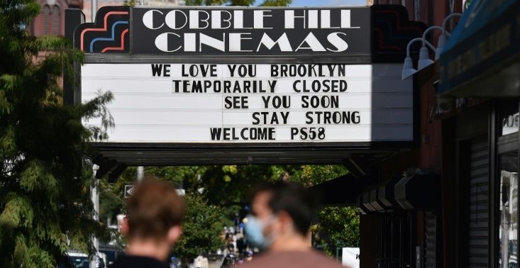 People walk past the Cobble Hill Cinemas movie theater in New York City, which has been closed for months due to the coronavirus pandemic. AFP