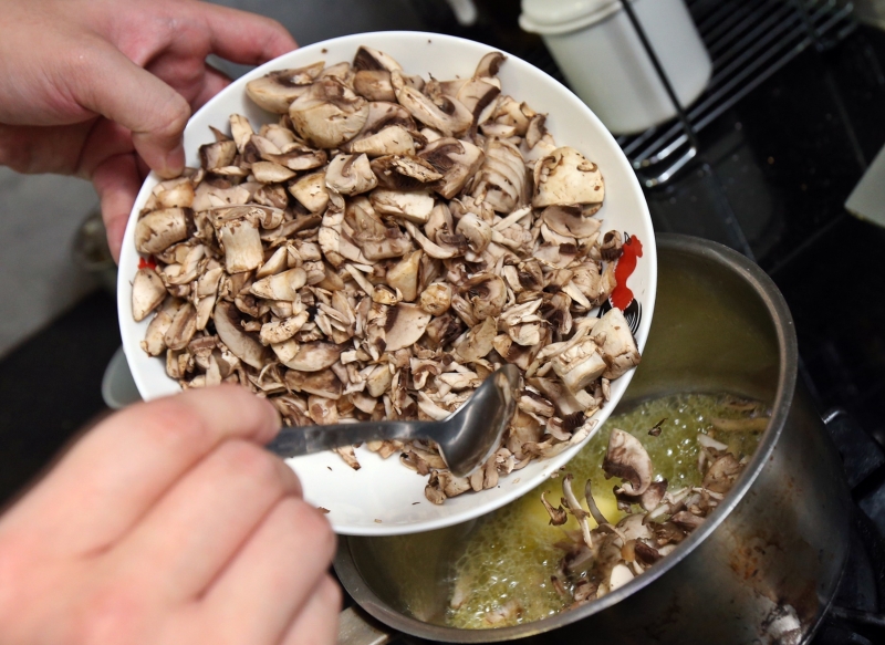 1.热锅后放入牛油，再倒入蘑菇片翻炒至水分蒸发。在水分将近干时，加入少许白蒜。