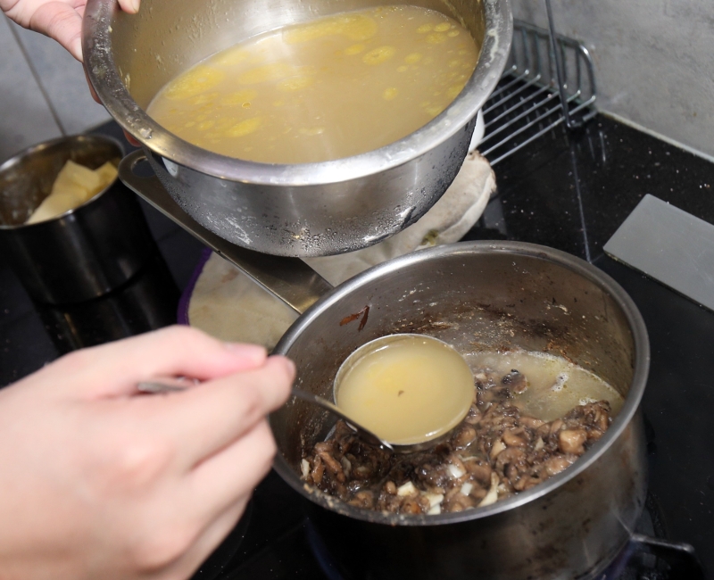 3.将蘑菇煮至微焦后，加入预先熬煮的高汤。汤汁必须覆盖蘑菇。