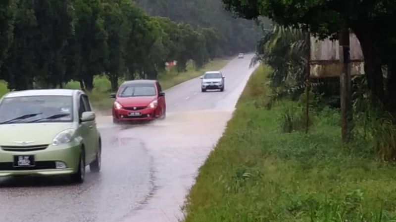 大雨导致永平通往巴力士隆路段路面积水，轿车被迫涉水而过。