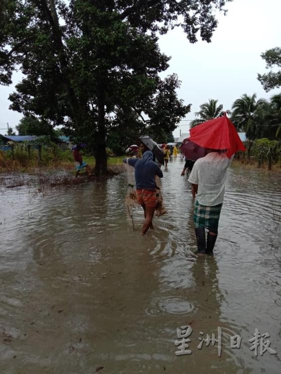 村民涉水往返家园。

